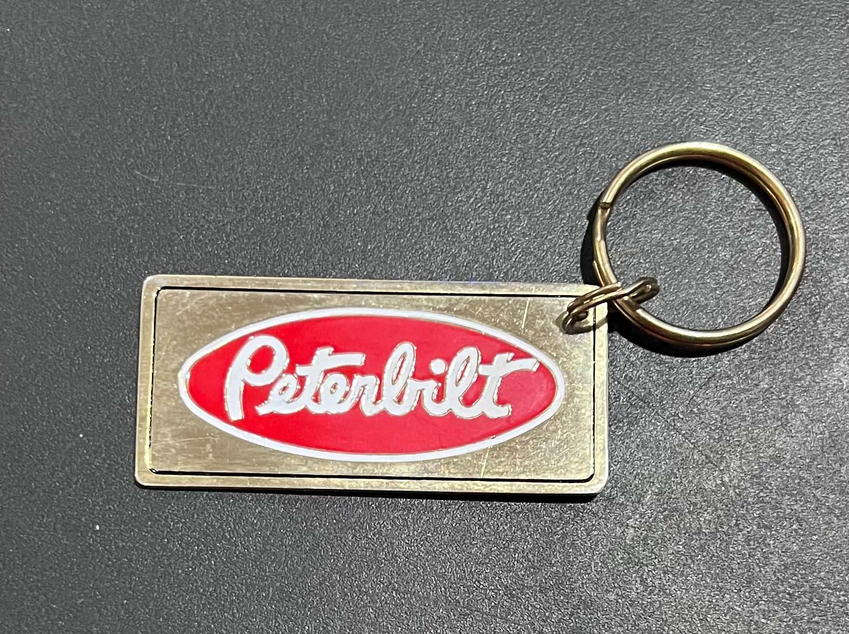 Peterbilt Logo Gold Plated Metal Keychain with Engravable Backside NOS Relic has been store safely away for decades and shows some wear but vintage from the 1980s