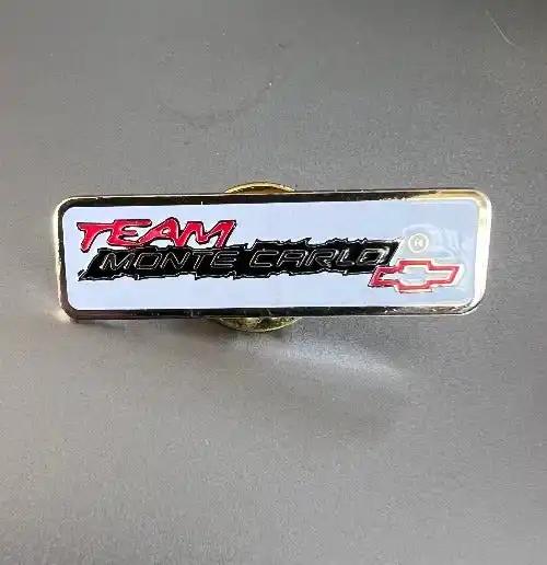 TEAM MONTE CARLO Pin Chevrolet Bowtie Logo Detailed Mint NOS. This rectangular pin is approximately 1 in long and 1/32 in wide, painted on gold metal and looks fan