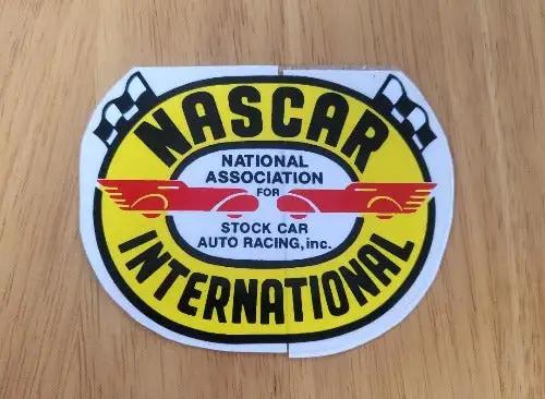 NASCAR International Decal Cross Flags Auto Racing NOS item. This relic has been stored for decades and the oval measure 2.75 in in width x 3.5 in in length. 